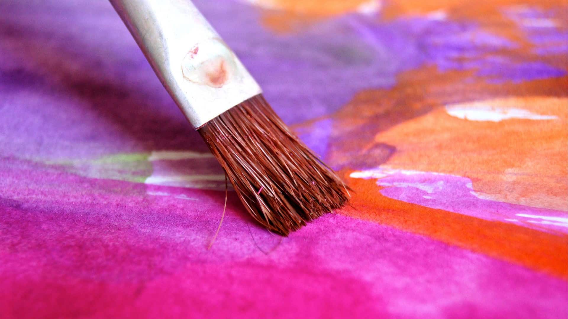 A person paints vibrant colors during a Maui arts and crafts workshop.