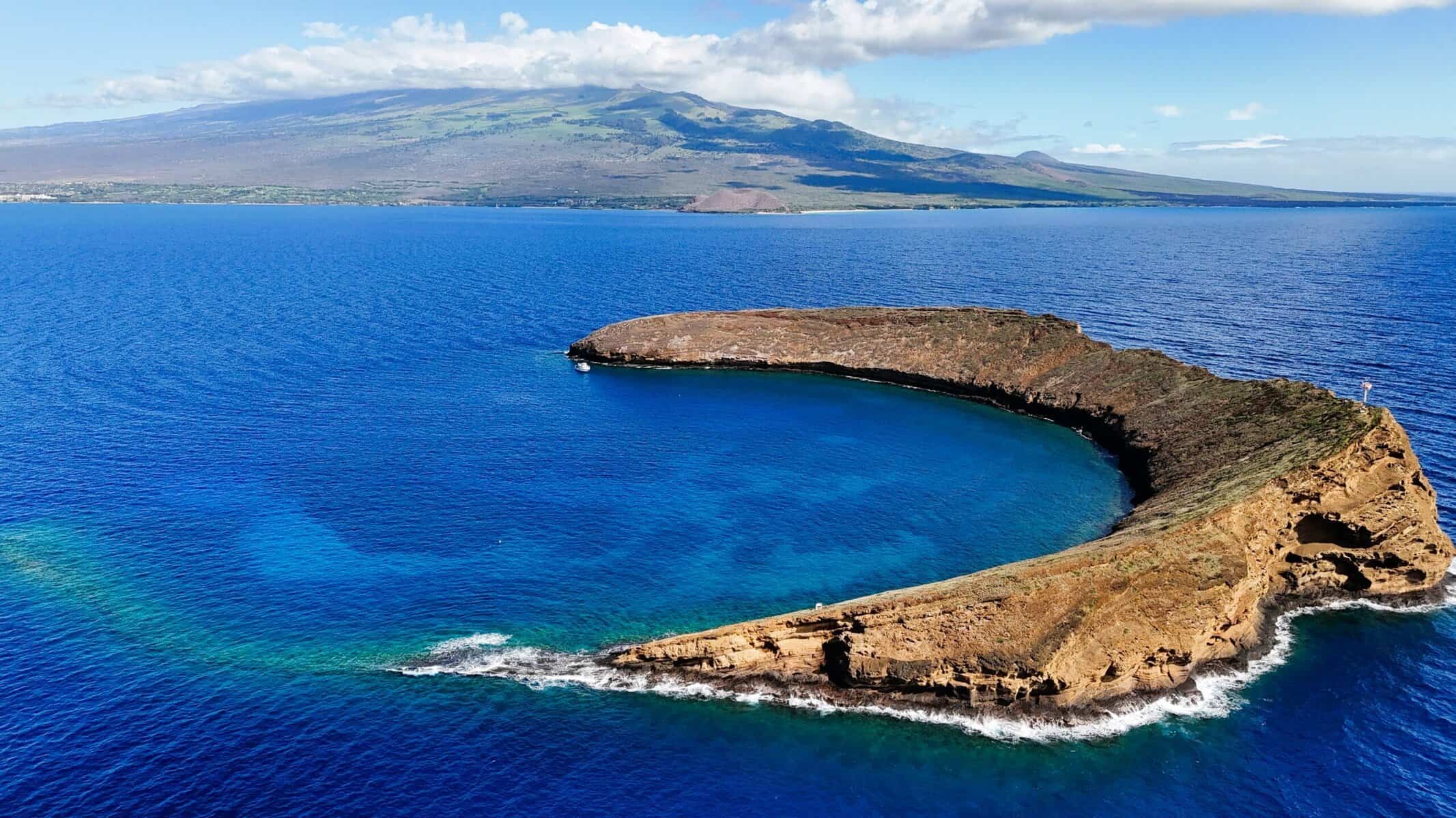 Aerial view of the renowned Molokini Crater surrounded by vibrant blue waters on Maui.